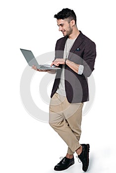 Man in casual clothes typing laptop isolated on white