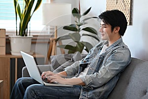 Man in casual clothes working, shopping online, surfing internet with laptop at home.