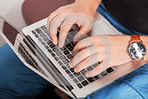 Man in casual clothing typing on laptop