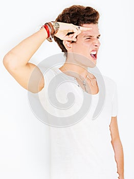 Man in casual fashion in studio with salute, crazy face and urban style and rebel youth attitude. Greeting hand gesture