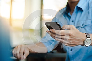 Man in casual form using mobile phone at modern office photo