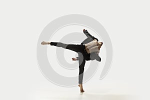 Man in casual style clothes jumping and dancing  on white background. Art, motion, action, flexibility