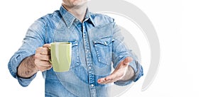 A man in casual style wear suggesting cup of coffee. Invite customer to taste. No face, closeup banner, white background, copy spa