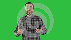 Man in casual walking and talking to the camera on a Green Screen, Chroma Key.