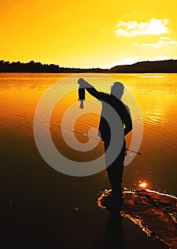 Man catches a fish in a lake