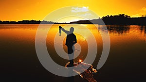 Man catches a fish in a lake