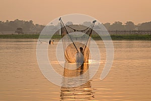 A man catching fish by net in Mandalay, Myanmar