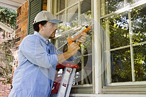 Man Caulking Window photo