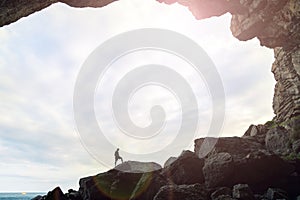 Man in the cave with a sky background.