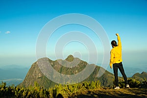 Man celebrating success on top of a mountain