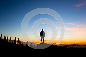 Man celebrating sunset looking at view in mountains