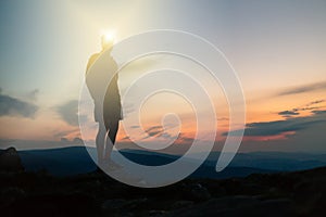 Man celebrating sunset looking at view in mountains photo