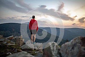 Uomo festeggia tramonto guarda montagne 