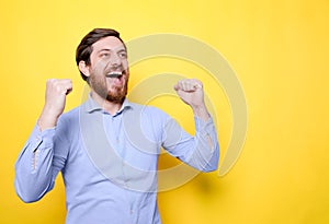 Man celebrating surprised and amazed for success with arms raised