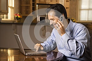 Man on Cell Phone and Laptop