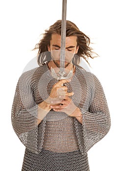 Man chain mail sword front of face eyes closed