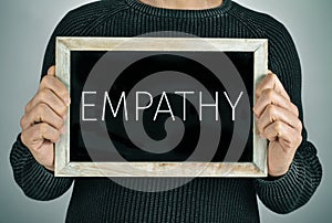 Man with a chalkboard with the text empathy photo