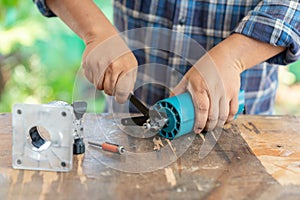 Man change cutting head of electric router in carpenter workshop