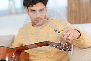 man changes guitar strings photo