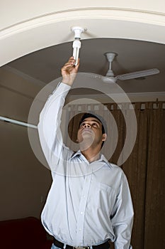 Man changing bulb to CFL