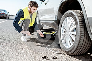 Man changing car wheel on the roadside