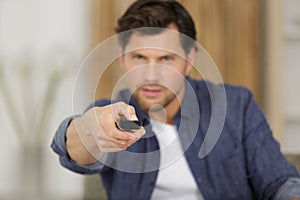 man changing channels while watching tv at home