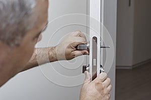 man changing the door lock at home