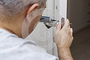 Man changing the door lock at home