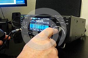 Man changing frequency on modern radio transceiver