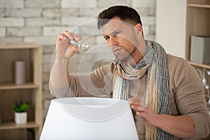 man changing light bulb in coffee shop