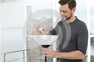 Man changing light bulb in lamp. Space for text
