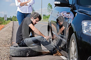 Man changing tire That are leaking His car broke down