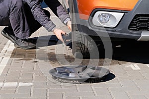 Man is changing wheel after a car break down. Damaged car tyre. Wheel balancing or repair and change car tire. Auto repair concept