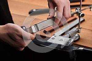 Man changing a whetstone in a manual sharpener machine