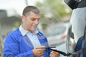 Man changing windscreen wipers on car