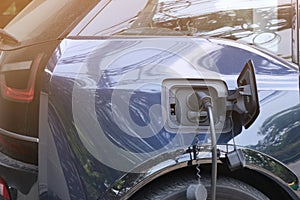 A man is charging an electric car at the electric charging station