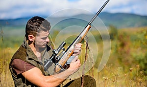 Man charging hunting rifle. Hunting equipment concept. Hunter khaki clothes ready to hunt nature background. Hunting