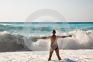 Man chasing the waves on Myrtos beach