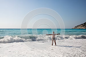 Man chasing the waves on Myrtos beach