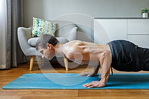 Man in chaturanga pose doing vinyasa flow at home