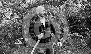 Man checkered shirt use axe. brutal and attractive male in forest. power and strength. lumberjack carry ax. bald