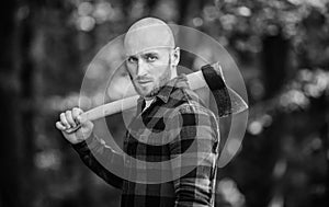 Man checkered shirt use axe. Brutal male in forest. Power and strength. Lumberjack carry ax. Bald woodsman. Harvest