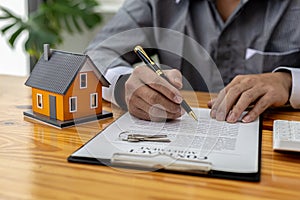 Man checking documents on table, housing salesman checking for correctness of contract documents before bringing customers to sign