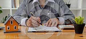 Man checking documents on table, housing salesman checking for correctness of contract documents before bringing customers to sign