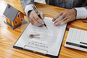 Man checking documents on table, housing salesman checking for correctness of contract documents before bringing customers to sign