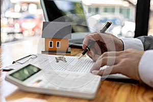 Man checking documents on table, housing salesman checking for correctness of contract documents before bringing customers to sign