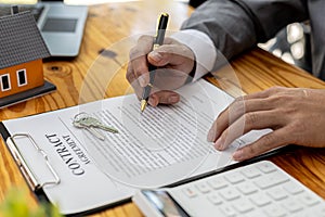 Man checking documents on table, housing salesman checking for correctness of contract documents before bringing customers to sign