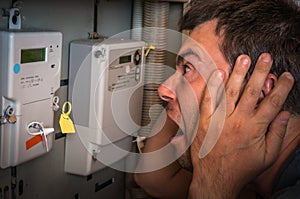 Man is checking electricity meter - expensive electricity concep