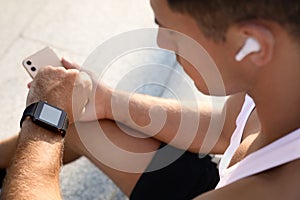 Man checking fitness tracker after training outdoors, closeup