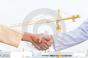 The man checking the hand with commitment to sucess at construction site and crane background photo